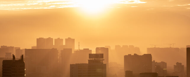 sun over a city in sepia tones